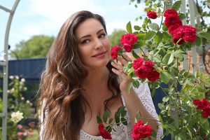 خانمی در حال بوییدن خوشبوترین گل برای باغچه رز